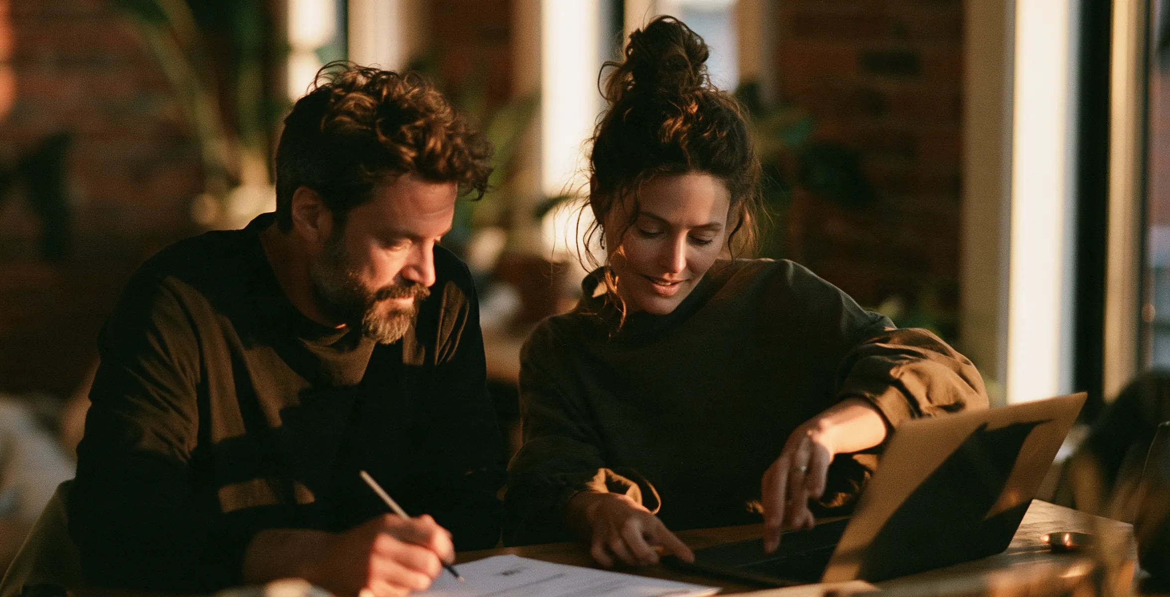 Couple qui compare les offres de renouvellement sur un ordinateur portable à la table de cuisine
